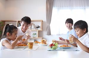 家族4人が食事をしている様子の写真です