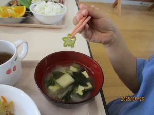 収穫したオクラを給食でお味噌汁にして食べる様子