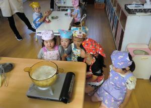 お団子をゆでるところを見守る園児たち