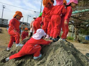 砂で遊ぶ園児の様子