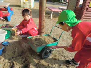砂で遊ぶ園児の様子