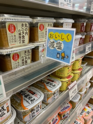 市内スーパーの商品棚で、減塩商品が売られている様子の写真です。